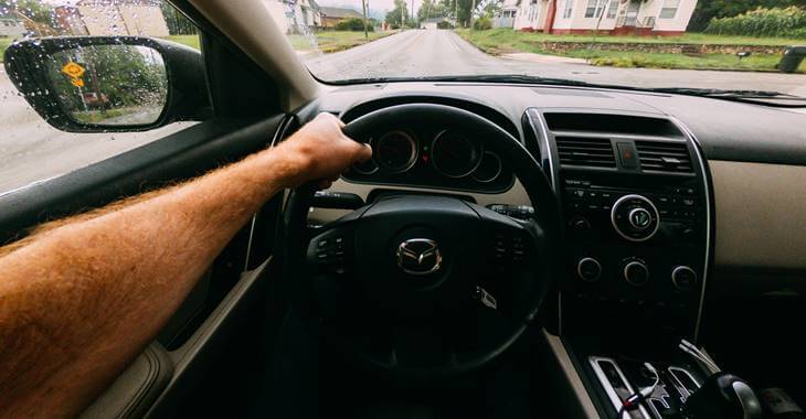 ruka na crnom volanu automobila Mazda