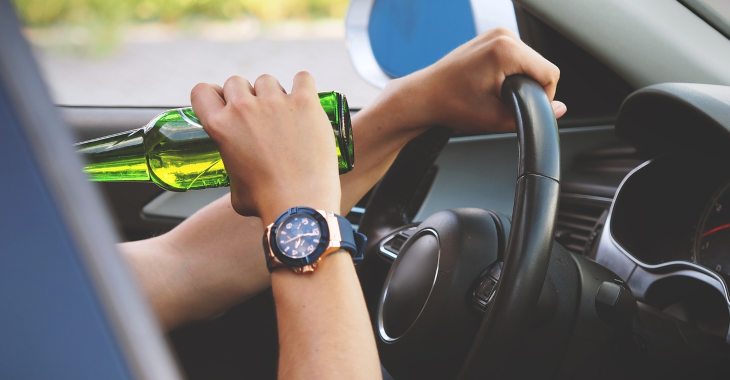 Muškarac koji pije pivo dok vozi kola